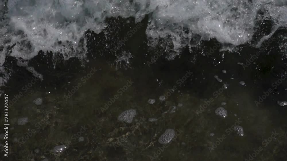 Slow motion of a foamy wave on a water surface as a background. Slow motion of a foamy wave on a water surface as a background.