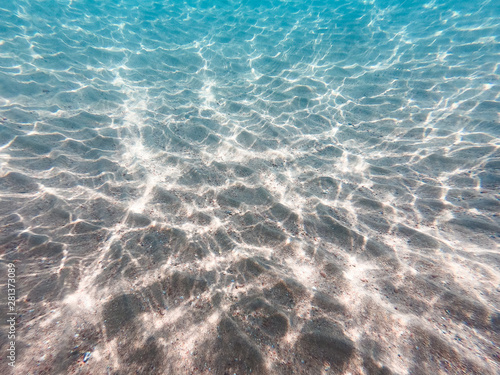 underwater background with sandy sea bottom. Beautiful texture of the sea and ocean water. Pure water texture.