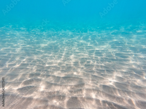 underwater background with sandy sea bottom. Beautiful texture of the sea and ocean water. Pure water texture.