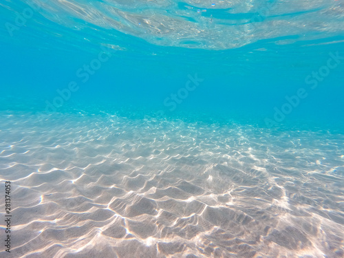 underwater background with sandy sea bottom. Beautiful texture of the sea and ocean water. Pure water texture. © Alwih