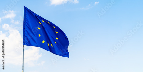 European Union flag against blue sky waving