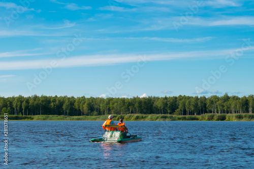 mother and son in life jackets, riding a catamaran in the open water, beautiful landscape