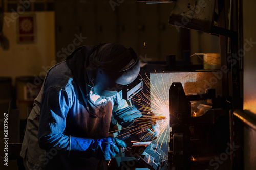 Worker is welding in factory