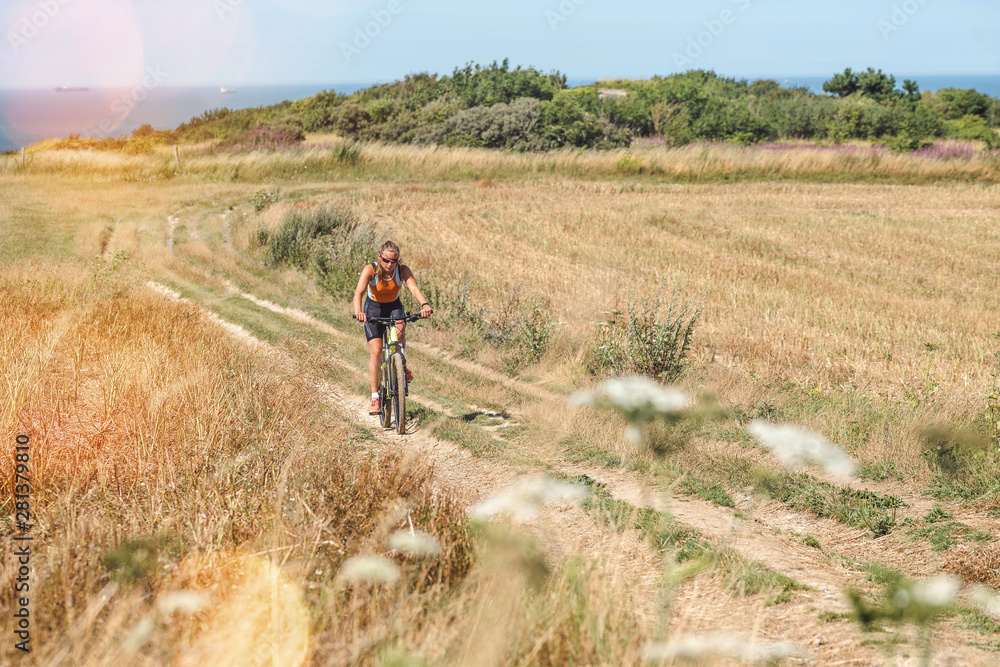 pretty young woman doing mountain bike in the summer sun pretty young woman doing mountain bike in the summer sun