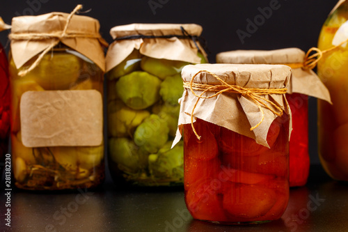  glass bottle with preserved food on black background