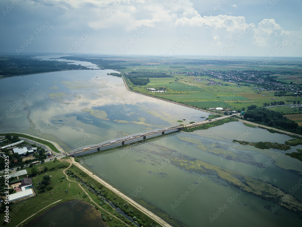 Aerial Drone Flight: View of the bridge over the river with cars. Olt river, Romania