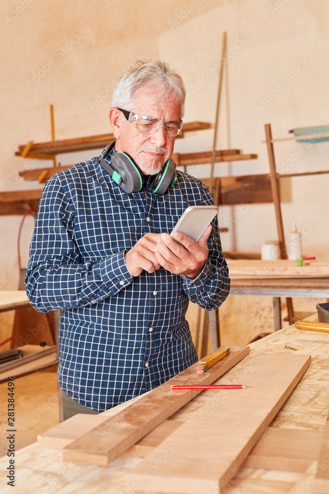 Senior as a craftsman with smartphone Senior as a craftsman with smartphone