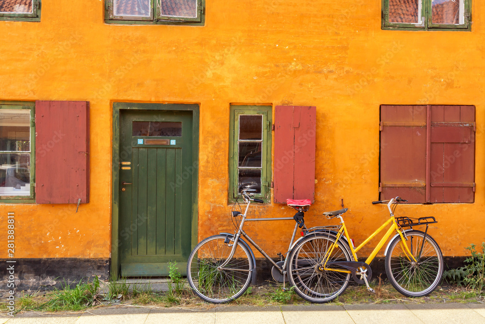 Picturesque of Copenhagen. Old yellow house of Nyboder district with bikes. Old Medieval district in Copenhagen, Denmark