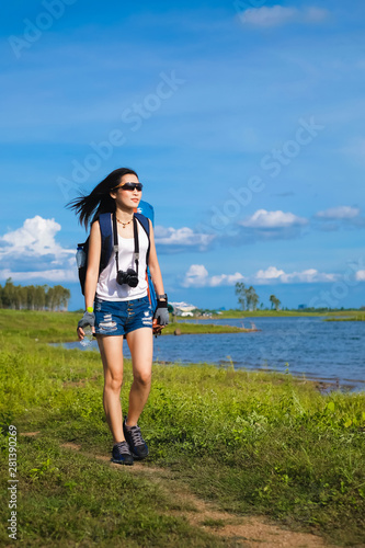 woman traveler standing near the lake background is the mountain and enjoying for beautiful view of nature on holiday.adventure concept. © Anusorn