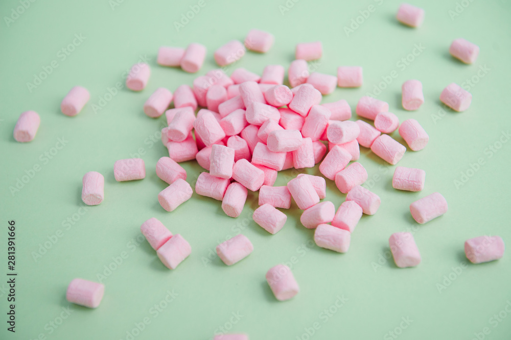 handful of pink mini marshmallows on a green background