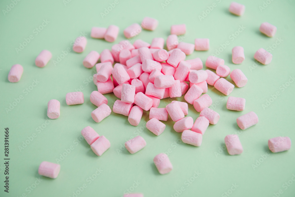 handful of pink mini marshmallows on a green background handful of pink mini marshmallows on a green background
