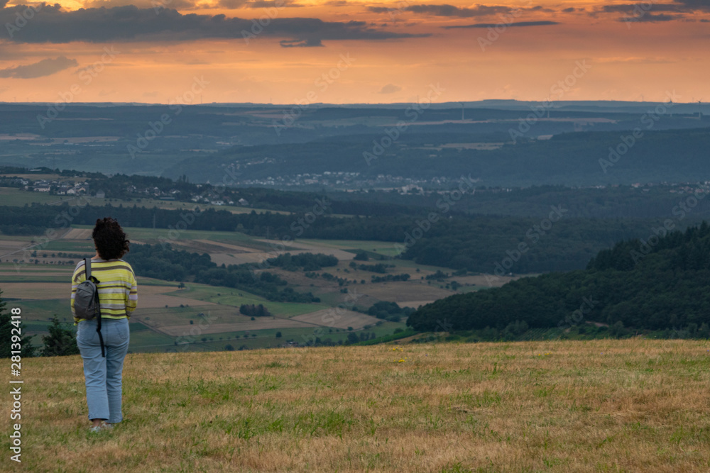 Eine Frau blickt am Abend in ein Tal, A woman looks into a valley in the evening