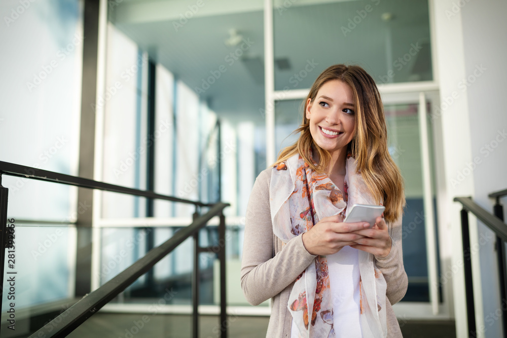 Outdoors portrait of beautiful young girl laughing and using cell phone Outdoors portrait of beautiful young girl laughing and using cell phone