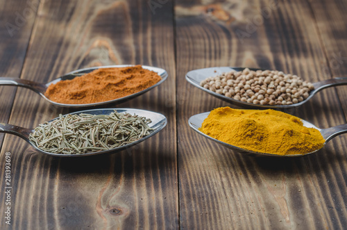 various spices in spoons on a wooden table. Selective focus