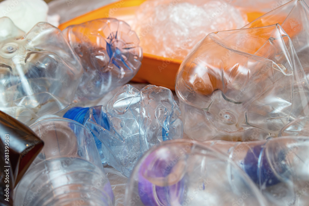 Lot of used plastic, crumpled empty bottles, packets, plastic orange dish, diaper, pollution recycle eco concept background close up selective focus Lot of used plastic, crumpled empty bottles, packets, plastic orange dish, diaper, pollution recycle eco concept background close up selective focus