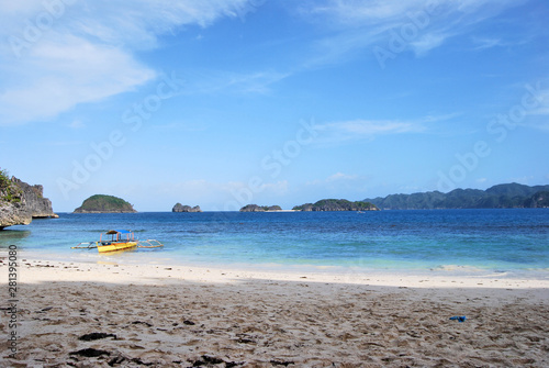 Natural landscape: tropical sand beach with crystal clear sea and a boat on the shore. Rocks and tropical beach, Caramoan Island, Philippines, Asia. photo