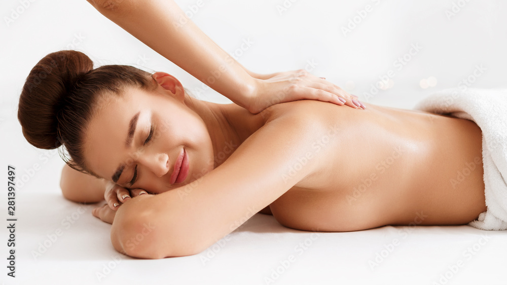 Beautiful woman receiving back massage in beauty parlor Beautiful woman receiving back massage in beauty parlor