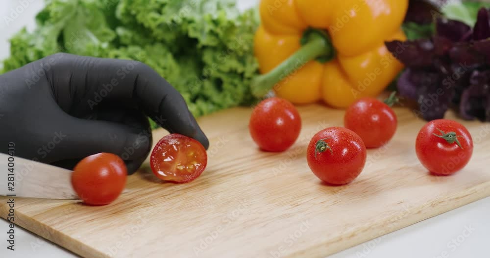 Chef cut the tomatoes, with a knife on a cutting board in slow motion. Chef cut the tomatoes, with a knife on a cutting board in slow motion.