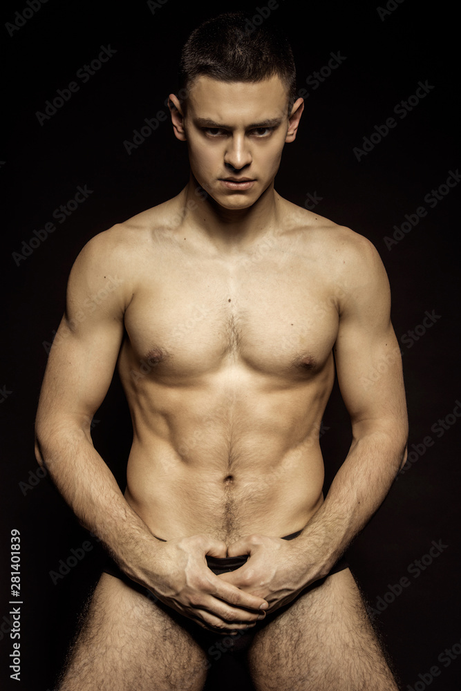 Strong stripped muscle male model in underwear on black isolated font background