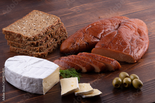 raw smoked cod caviar with camembert cheese, olives, bread on wooden background photo