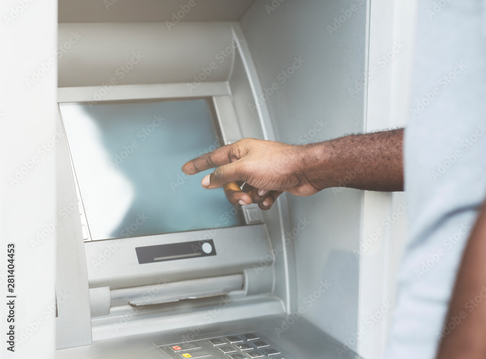 Unrecognizable african american man using ATM to get cash Unrecognizable african american man using ATM to get cash