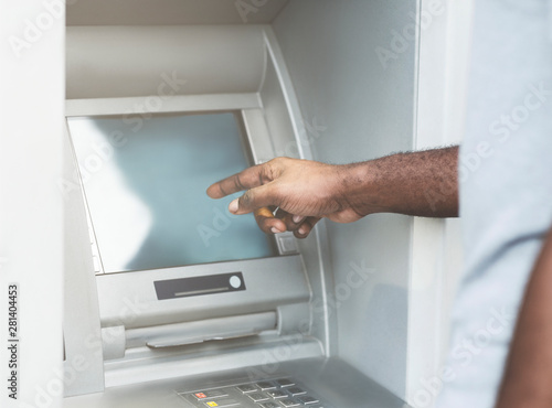 Unrecognizable african american man using ATM to get cash