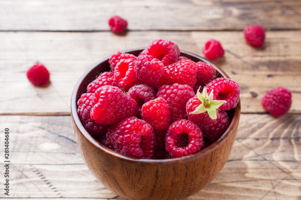 Fresh red raspberry berries in a wooden plate. Fresh red raspberry berries in a wooden plate.