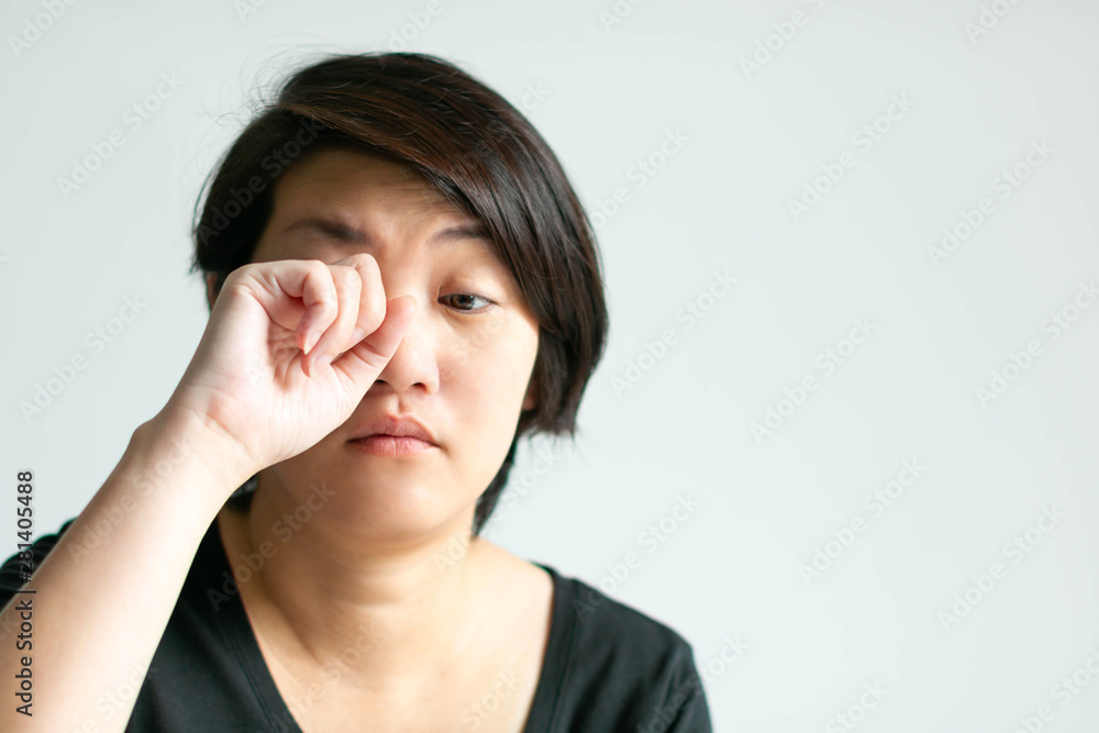 Woman in sleepy face is rubbing her eye. Woman in sleepy face is rubbing her eye.