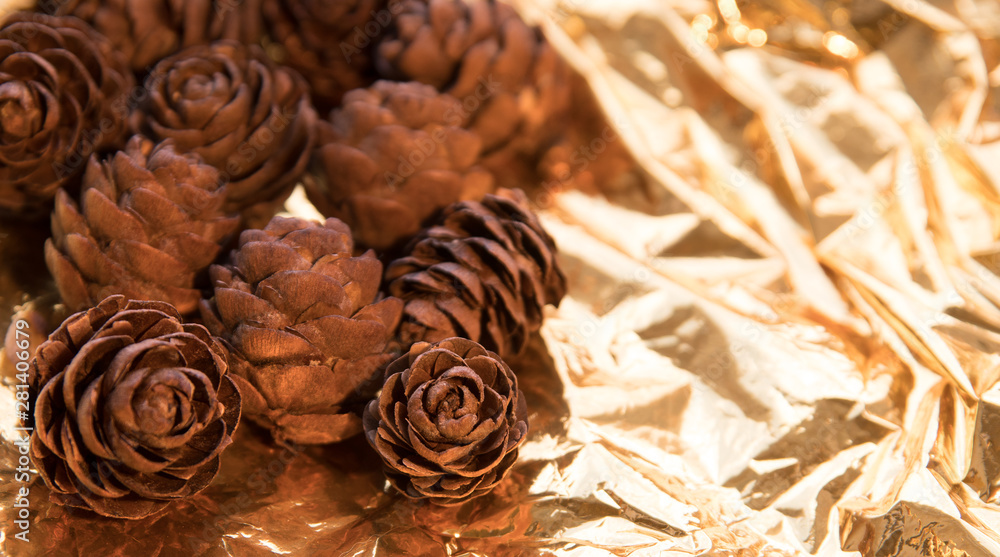Fototapeta premium pine cone on a gold background. postcard for autumn and new year