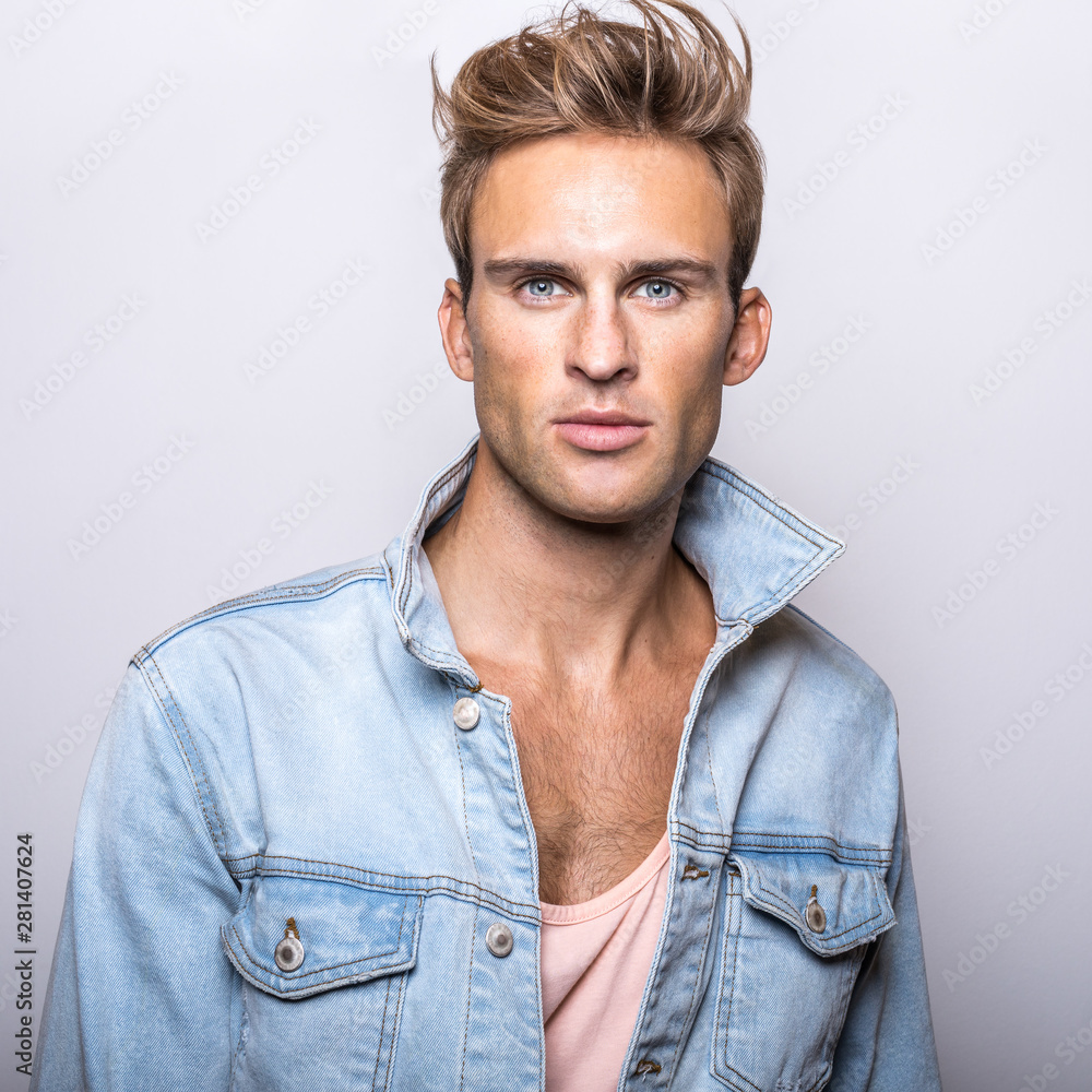 Handsome young man in jeans jacket pose in studio. Handsome young man in jeans jacket pose in studio.