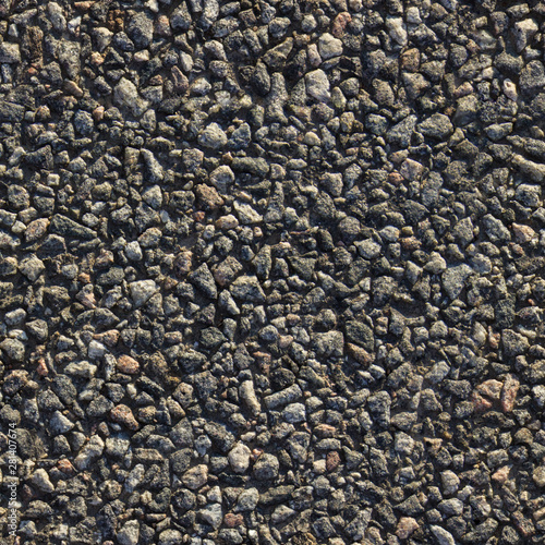 Close up asphalt road texture. Gray gravel stones seamless background