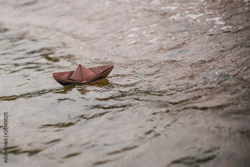 brown paper boat floats on water