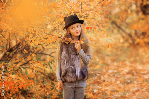 Autumn portrait of a cute girl in a hat. Girl 8 years old walks in the autumn park.