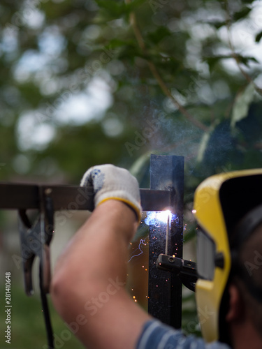 Welder works . Welding of the metal frame of the fence