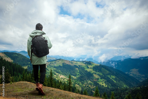 Creative background, A man is giant, a man is a tourist, he walks through a mountainous area with a backpack. The concept of Guliver, active tourism, recreation, the Carpathians. Mixed media