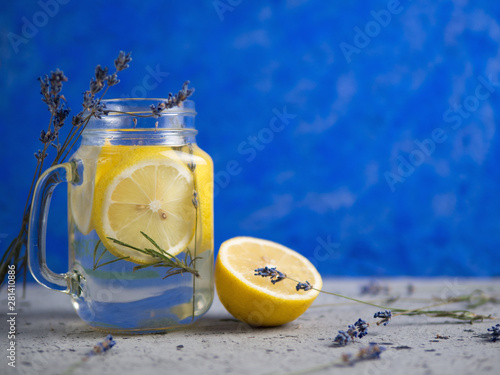 Lavender water with lemon in a jar on a blue background