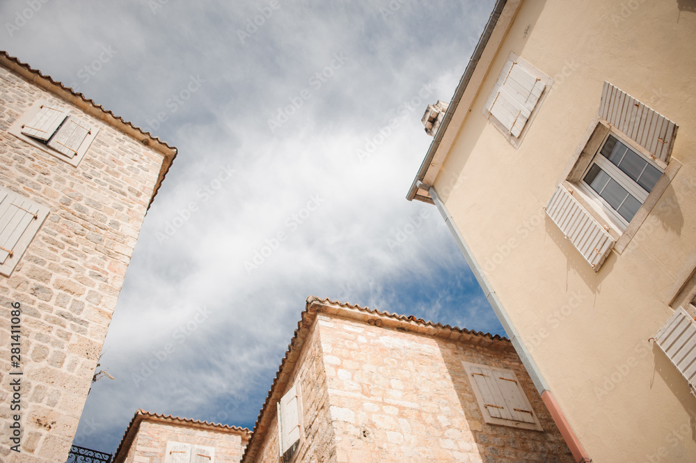 the tops of medieval stone buildings against a cloudy sky the tops of medieval stone buildings against a cloudy sky
