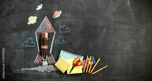 School blackboard background with some stationery and school supplies. Chalk drawing in white and colors.