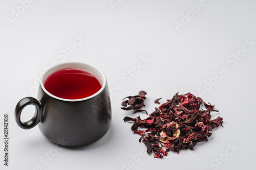 red tea Hibiscus in a black mug on a white background