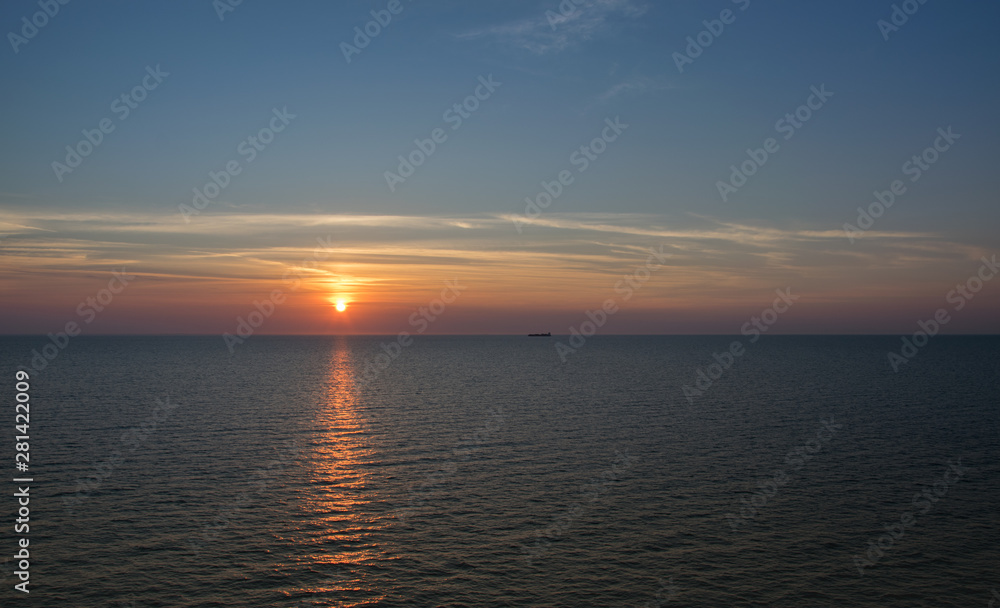 Sunset in the sea on a warm summer evening, seascape.