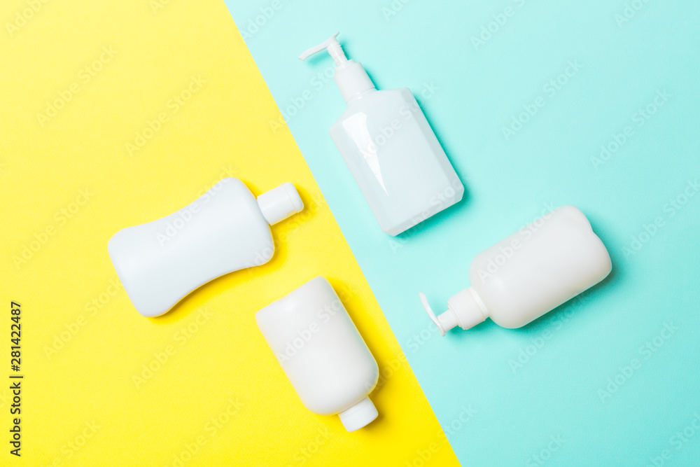 Set of White Cosmetic containers isolated on yellow and blue background, top view with copy space. Group of plastic bodycare bottle containers with empty space for you design Set of White Cosmetic containers isolated on yellow and blue background, top view with copy space. Group of plastic bodycare bottle containers with empty space for you design