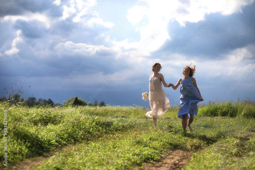 Young girls are walking in the field