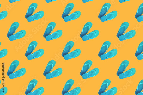 Colorful pattern of green flip flops isolated on yellow background