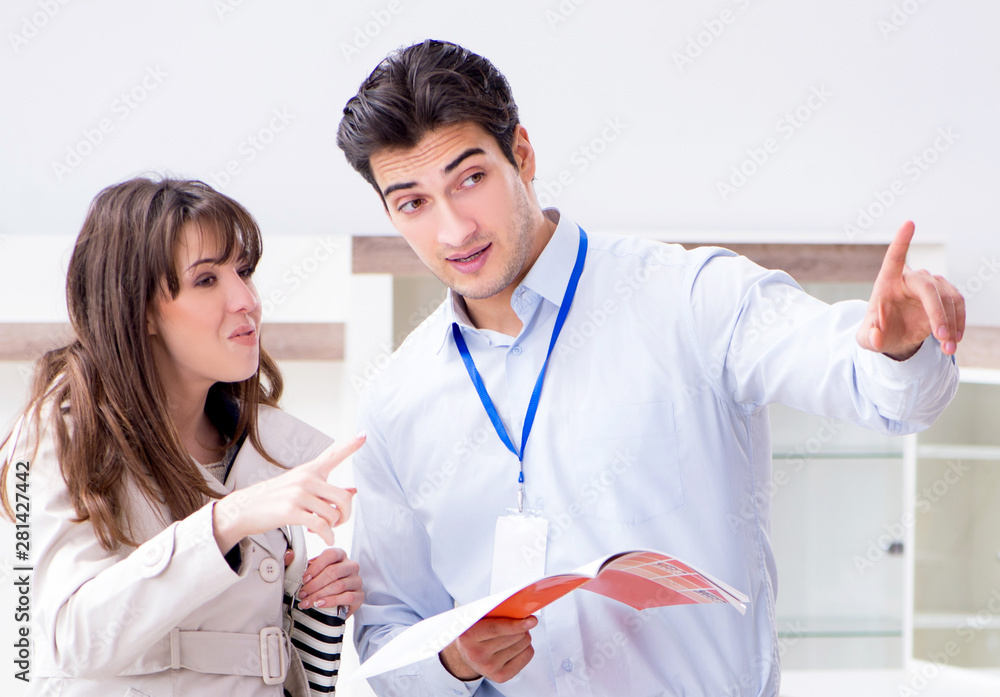 Fototapeta premium Salesman explaining to woman customer at furniture store
