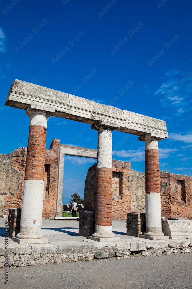 Tourists at the Portico of Concordia Augusta on the Forum of the ancient city of Pompeii in a beautiful early spring day