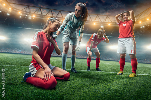 Sad Female Soccer players on a professional soccer stadium. Girls Team crying © Alex