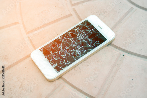 broken smartphone screen. Smartphone with a broken screen on the tile floor. Side view broken phone. negligence