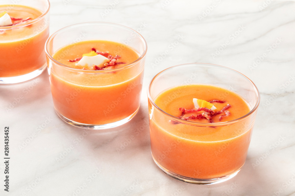 Salmorejo, Spanish cold tomato and bread soup, in glasses on a marble background with a place for text Salmorejo, Spanish cold tomato and bread soup, in glasses on a marble background with a place for text