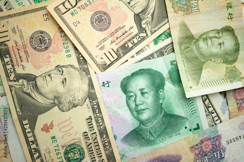US dollar stack and Chinese yuan banknotes on the table The concept of a trade war between the United States and China