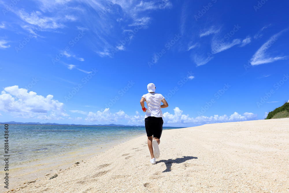 南国の美しいビーチを走る男性